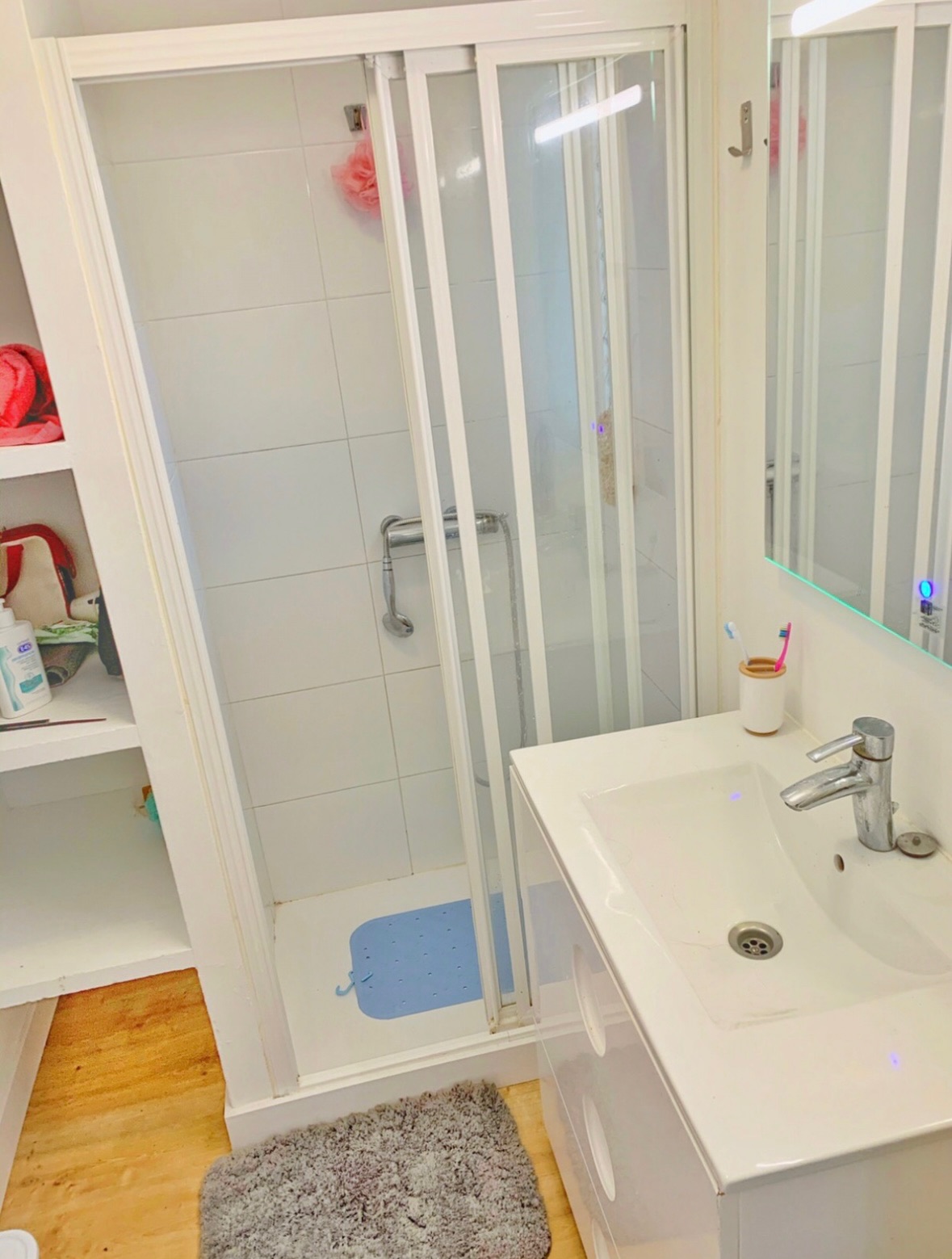 Baño común · plato de ducha con mampara, lavabo con mueble y espejo