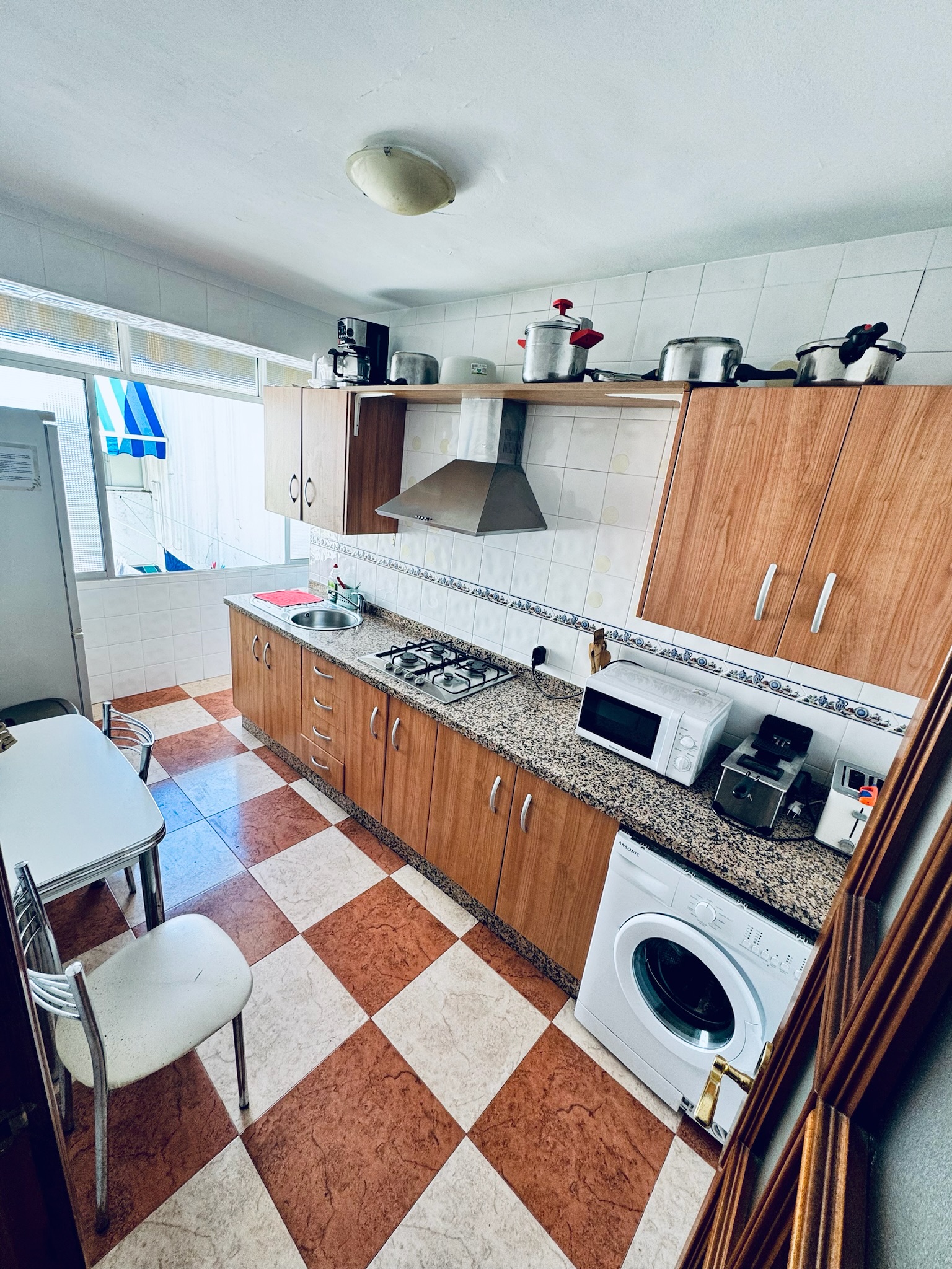 Shared kitchen · general view with worktop, gas hob, sink, oven, microwave and washing machine